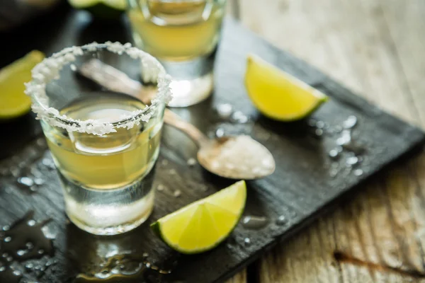 Gold Tequila Shots auf rustikalem Holz Hintergrund — Stockfoto