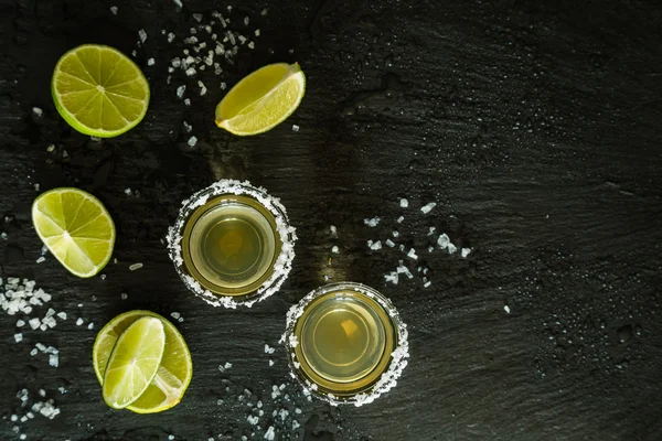 Colpi di tequila d'oro su sfondo in legno rustico — Foto Stock