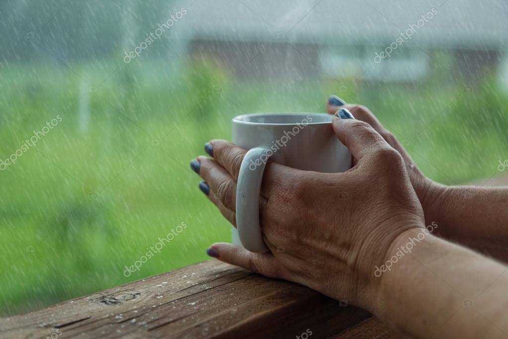 Female Hands Holding Cup Of Coffee In The Rainy Day Stock Photo By C Anaumenko