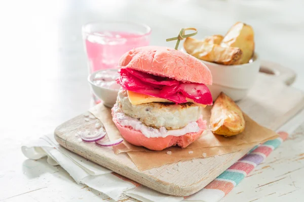 Hamburguesa a la parrilla de pollo rosa sobre fondo de madera — Foto de Stock