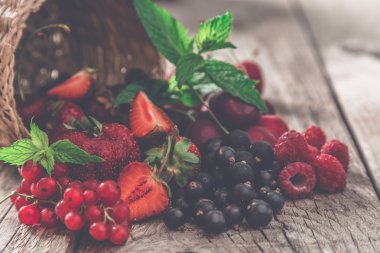 Rustik arka plan üzerinde renkli meyveleri yelpazesi