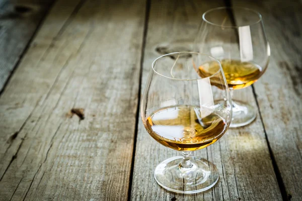 Cognac in bril op rustieke backgrpund — Stockfoto