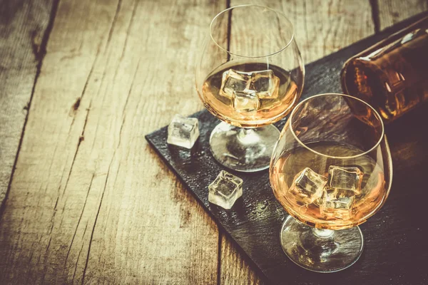Cognac i glas på rustika backgrpund — Stockfoto