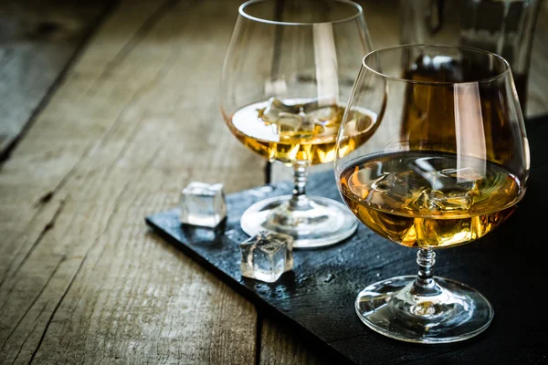 Cognac i glas på rustika backgrpund — Stockfoto