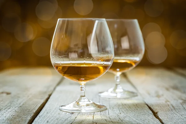 Cognac in glasses on rustic backgrpund — Stock Photo, Image