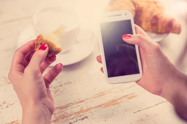 Mujer joven sosteniendo croissant — Foto de Stock