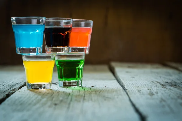 Selectie van kleurrijke geschoten dranken op witte houten achtergrond — Stockfoto