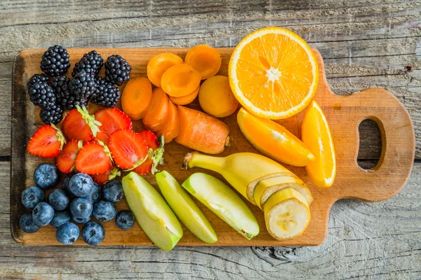 Плоды и ягоды на деревянной доске — стоковое фото