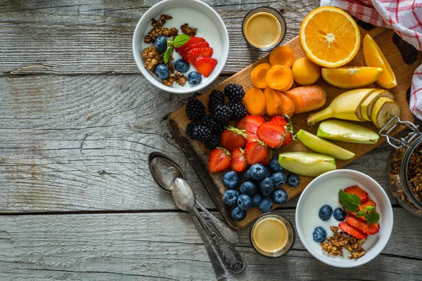 Reggeli - joghurt, granola gyümölcsök és kávé — Stock Fotó