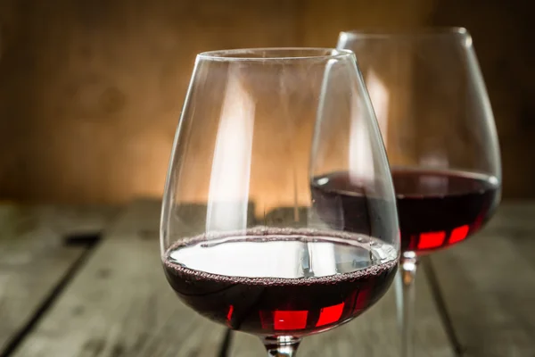 Bicchieri con vino rosso su fondo rustico in legno — Foto Stock