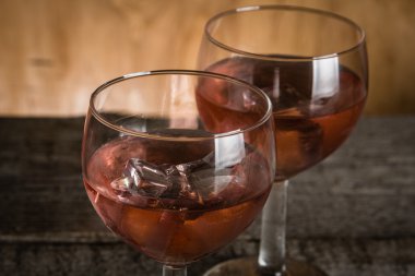 Rustik ahşap zemin üzerine gül şarap gözlük