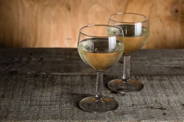 Óculos com vinho branco sobre fundo de madeira rústica — Fotografia de Stock