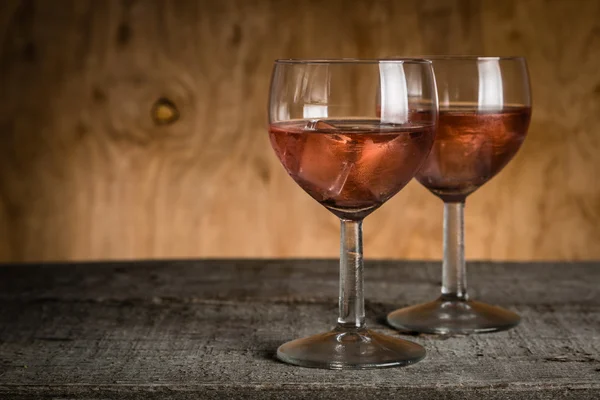 Lunettes avec vin de rose sur fond de bois rustique — Photo