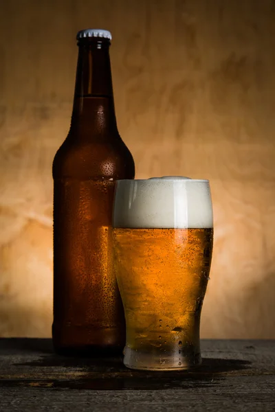 Piwo w butelce i szklanki z lodem krople — Zdjęcie stockowe