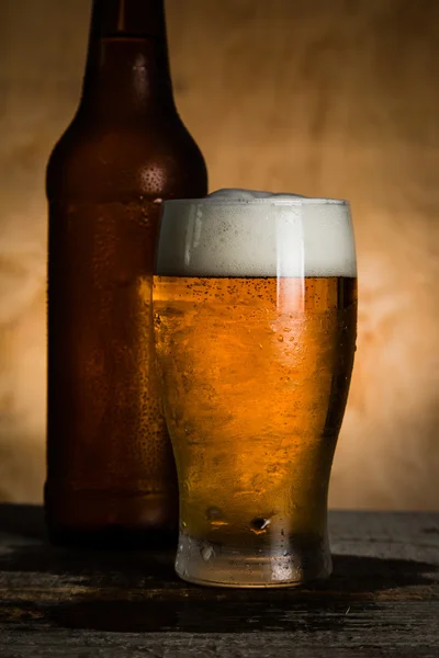 Cerveja em garrafa e vidro com gotas de gelo — Fotografia de Stock