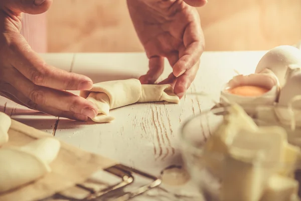 Baker, takže croissanty na rustikální dřevo pozadí — Stock fotografie