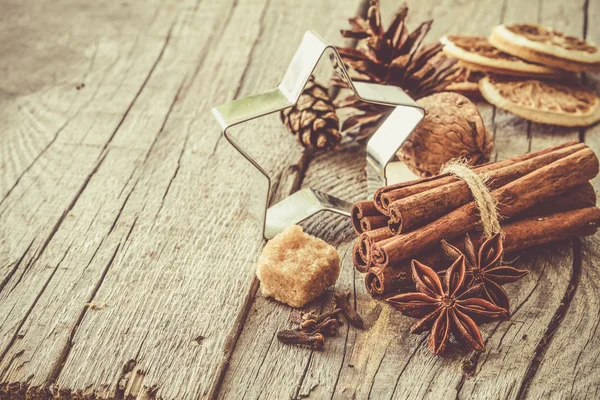 Auswahl an weihnachtlichen Gewürzen auf rustikalem Holzgrund — Stockfoto