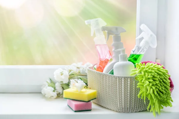 Concetto di pulizia primaverile - forniture per la pulizia e fiori su sfondo sfumato — Foto Stock