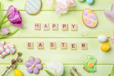 Paskalya konsepti - yeşil ahşap arka planda çiçekli kurabiyeler