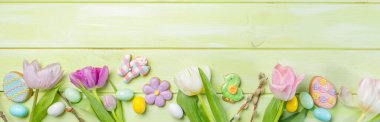 Paskalya konsepti - yeşil ahşap arka planda çiçekli kurabiyeler