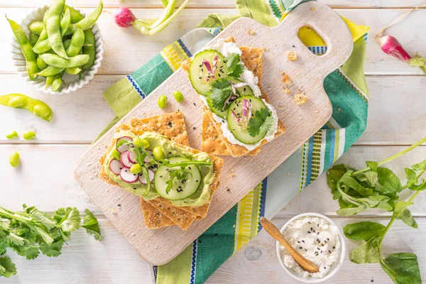 Concepto de alimentación saludable - panes crujientes con pepino y rábano sobre fondo blanco —  Fotos de Stock
