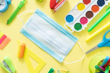 Okul konseptine geri dönelim. Parlak sarı arka planda renkli okul malzemeleri.