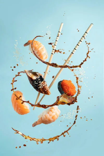 Koncepcja sushi - lewitacja z wyborem bułek i sushi, rozpryski sosu sojowego — Zdjęcie stockowe