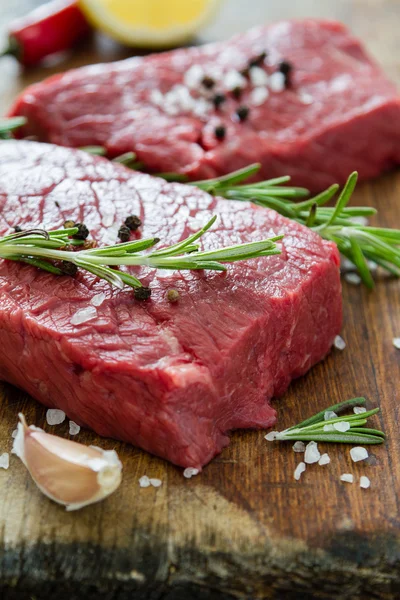 Roh geschnittenes Fleisch mit Rosmarin — Stockfoto