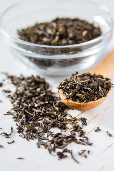 Black tea in spoon and glass jar — Stock Photo, Image