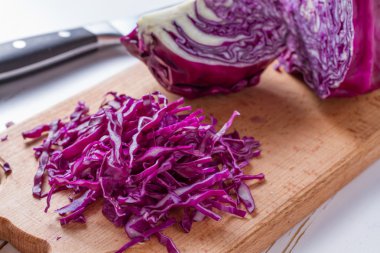 Ahşap tahta üzerinde dilimlenmiş kırmızı lahana