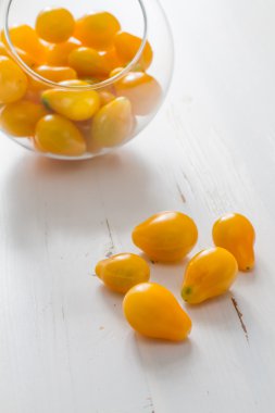 Bir cam kabın içinde sarı domates