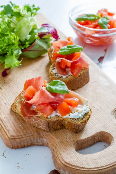 Bruschetta de tomate con hojas de albahaca —  Fotos de Stock