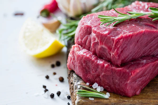 Raw sliced meat with rosemary — Stock Photo, Image