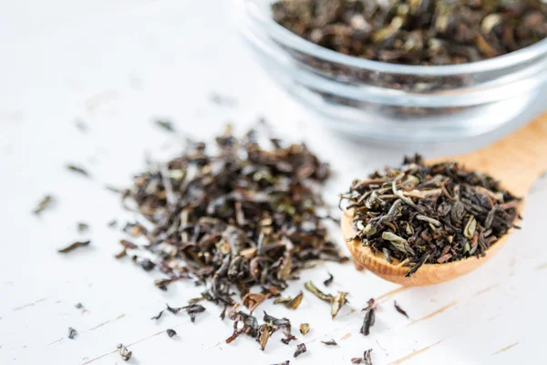 Black tea in spoon and glass jar — Stock Photo, Image