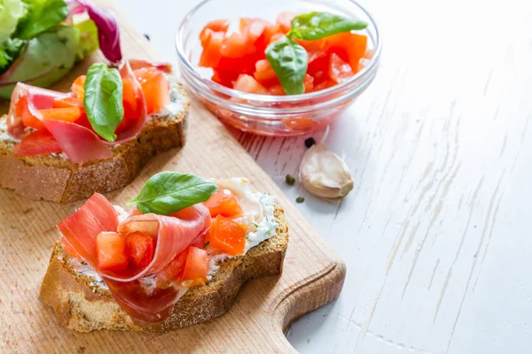 Tomato bruschetta with basil leafs — Stock Photo, Image