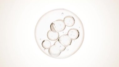 Baloncukların içinde hareket eden sıvı makrosu. Deri bakım serumu damlacıkları bir araya geliyor. Kozmetik nemlendirici sıvı konsepti. Yüksek kalite 4k görüntü