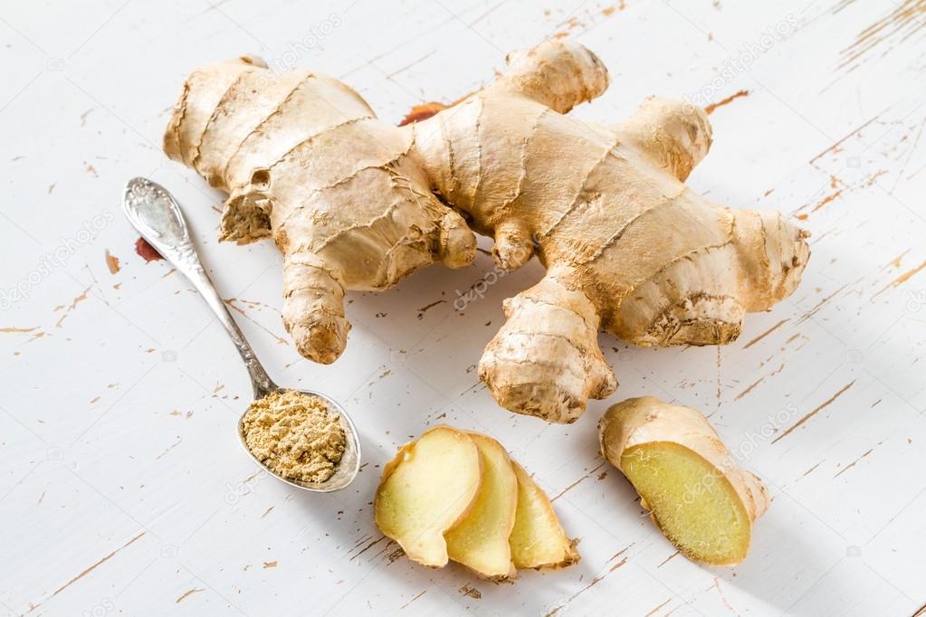 Ginger root on white wood background