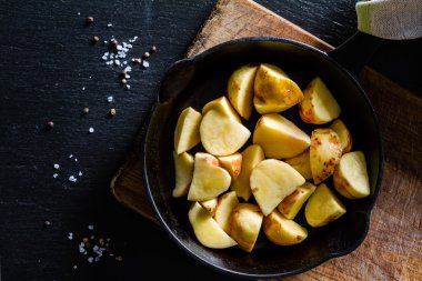 Çiğ patates dilimleri ile otlar, baharatlar