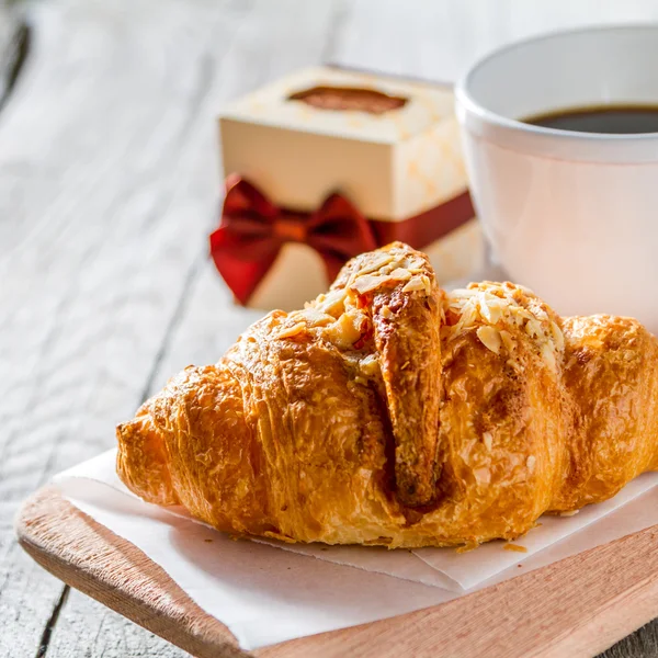 Deliciosos croissants frescos com café e presente — Fotografia de Stock