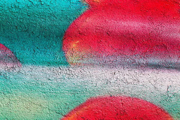 A fragment of colorful graffiti painted on a concrete wall. Abstract urban background for design.