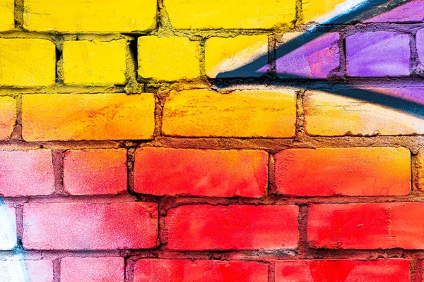 A fragment of colorful graffiti painted on a brick wall. Abstract background for design.