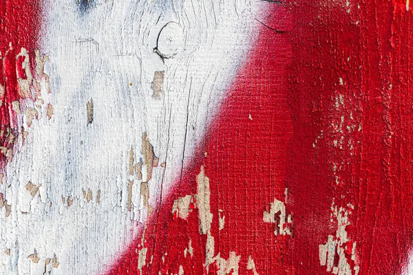 A fragment of colorful graffiti painted on a wooden board with peeling paint close-up. Abstract background for design.