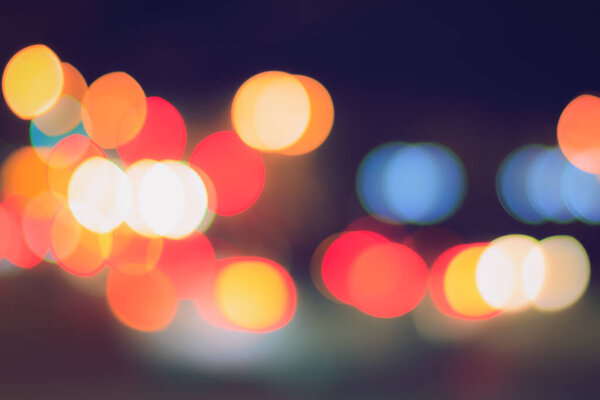 Blurred lights of headlights of cars and lanterns in the night city. Abstract bright bokeh.