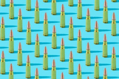 Üst üste 7.62 mm AK-47 altın mermi, mavi pastel arka planda desen