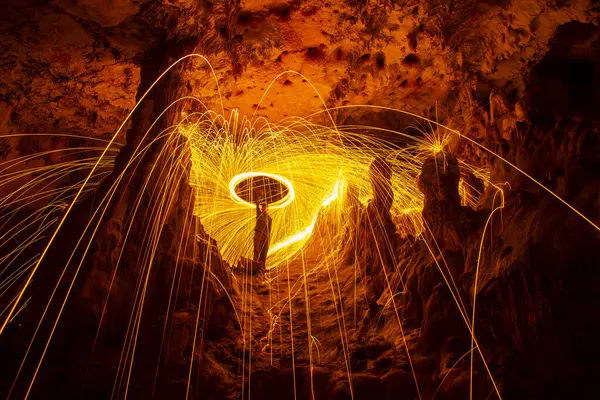 man doing pyrotechnic display in cave