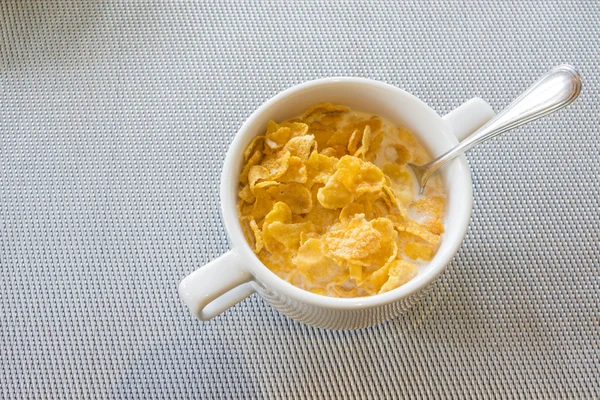 Ciotola di cereali e cucchiaio con latte . — Foto Stock