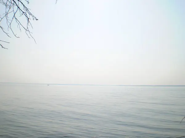 Gökyüzünün sudaki yansıması, uzak bir sahil, sıra dışı şekilli bulutlar..