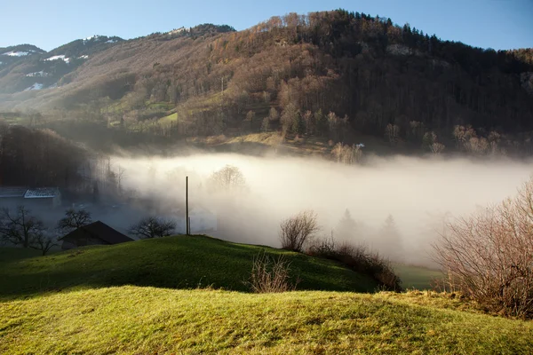Mlha, stoupající a úžasnou horskou scenérii poblíž Lungern, Švýcarsko — Stock fotografie