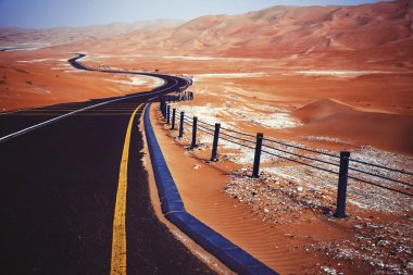 Kum tepeleri Liwa Oasis, Birleşik Arap Emirlikleri üzerinden dolambaçlı siyah asfalt yol