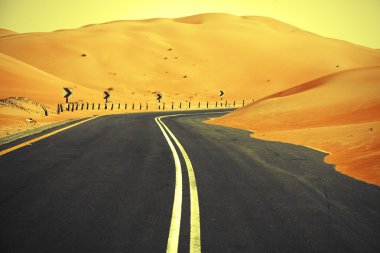 Kum tepeleri Liwa Oasis, Birleşik Arap Emirlikleri üzerinden dolambaçlı siyah asfalt yol